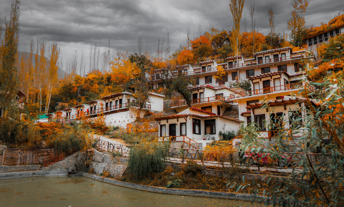 Offto Resort Karimabad surrounded by golden autumn trees beneath a cloudy sky
